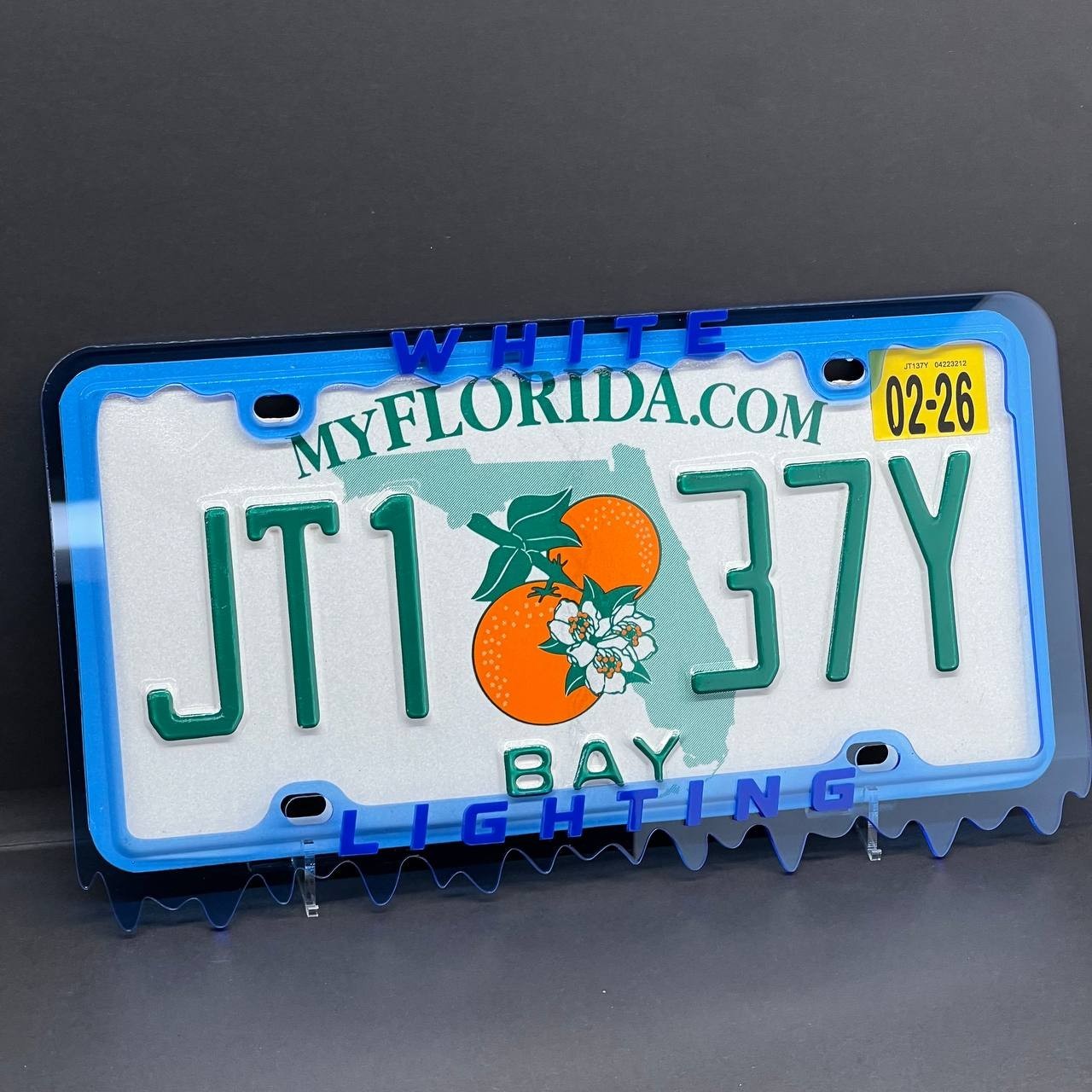 An acrylic license plate frame fitted around a license plate
