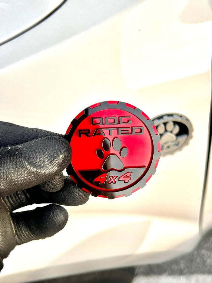 A gloved hand holding an acrylic badge against a car panel