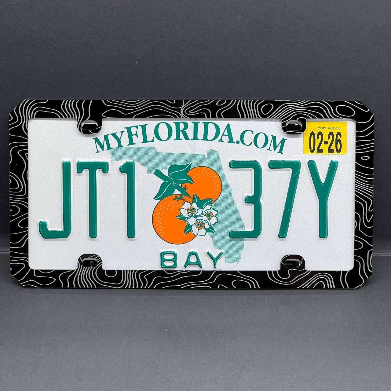 An acrylic license plate frame fitted around a license plate