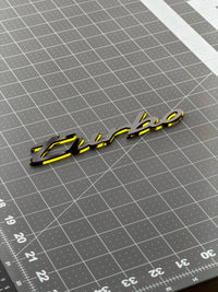 Porsche turbo acrylic emblem on a cutting mat showing its length