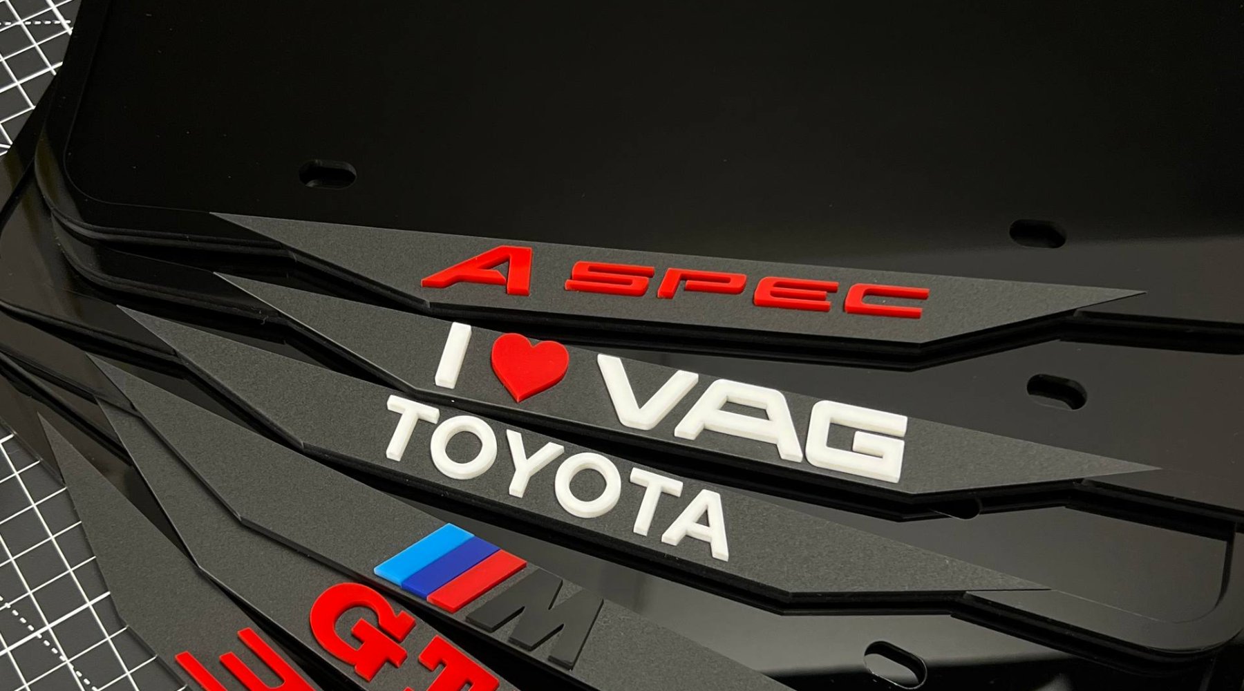 A stack of custom logo acrylic license plate frames