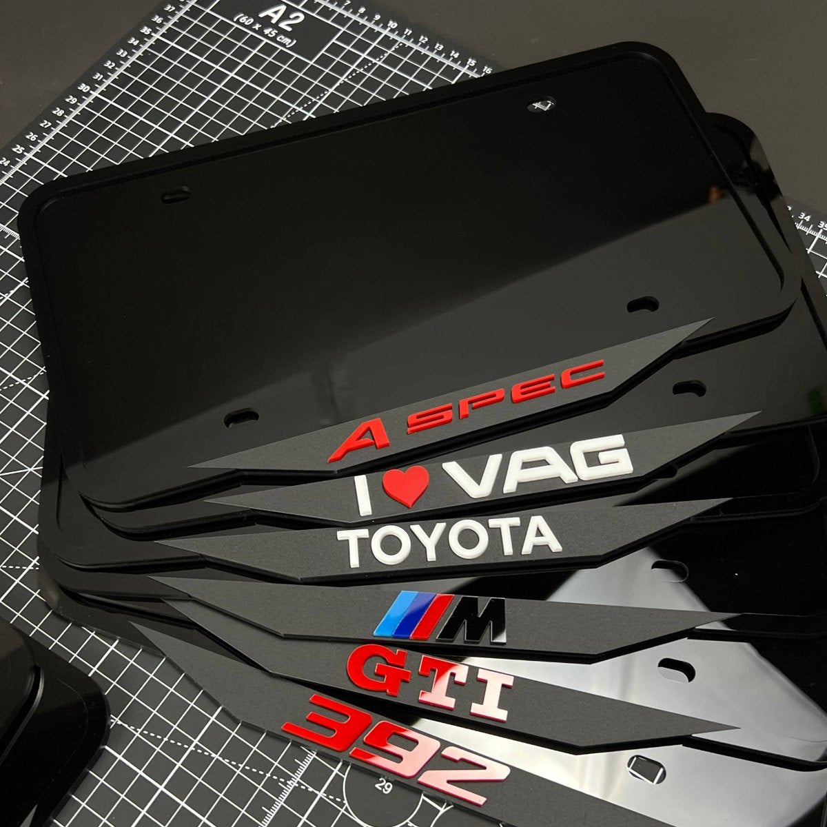 A production run of custom logo acrylic license plate frames